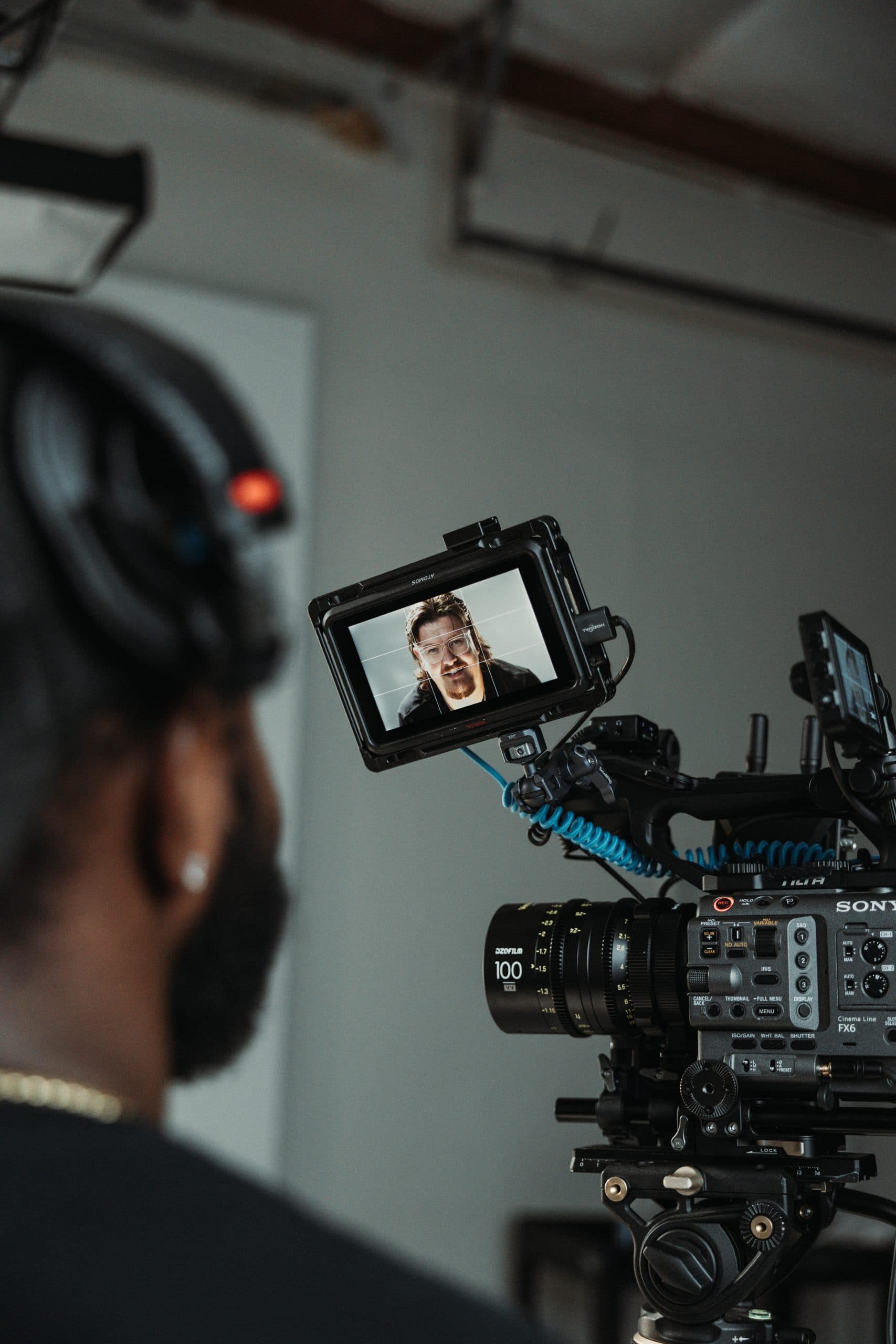 Over-the-shoulder view of a camera operator with the talent framed on the monitor