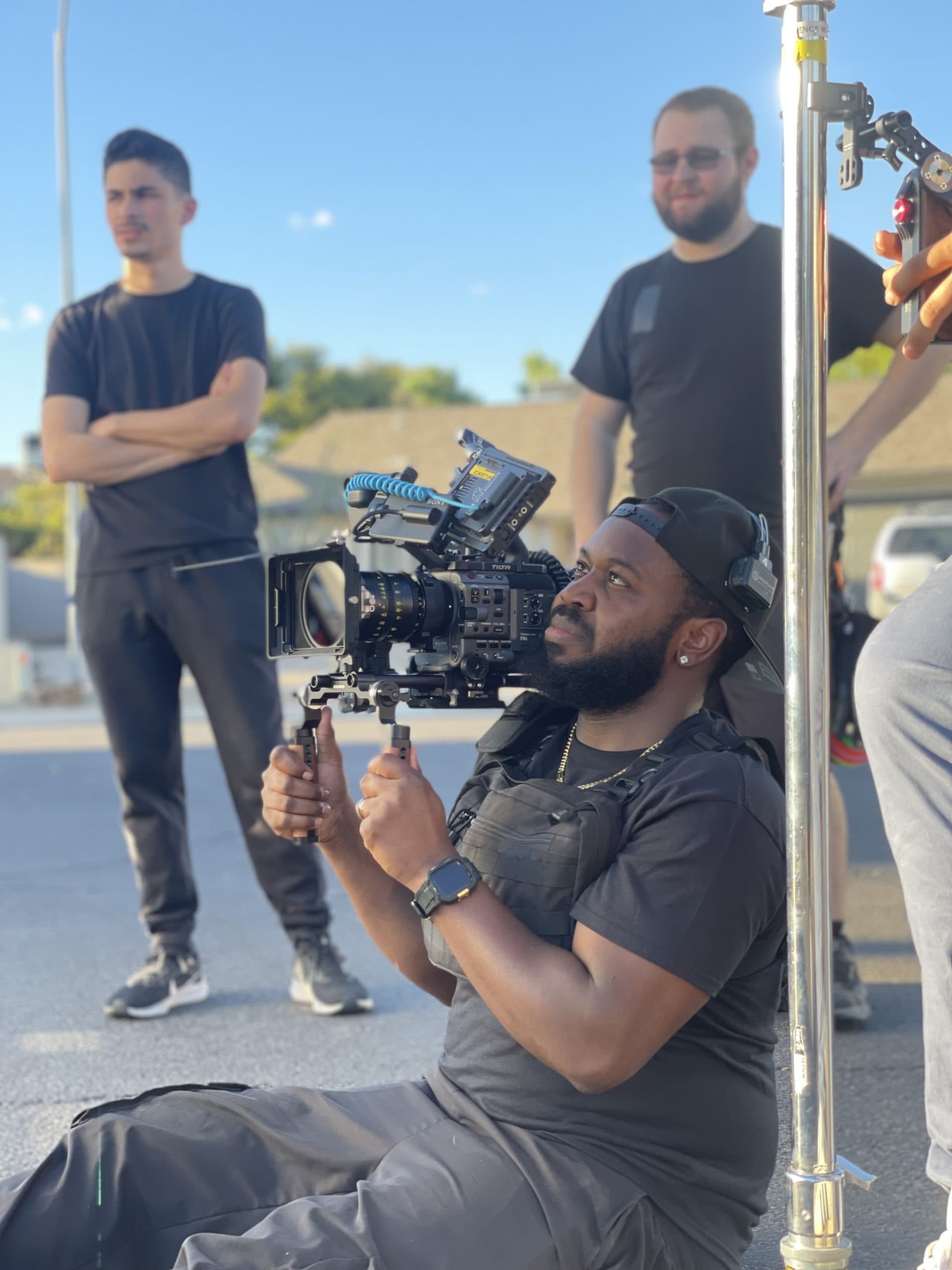 Crew filming outdoors with a gimbal rig at golden hour