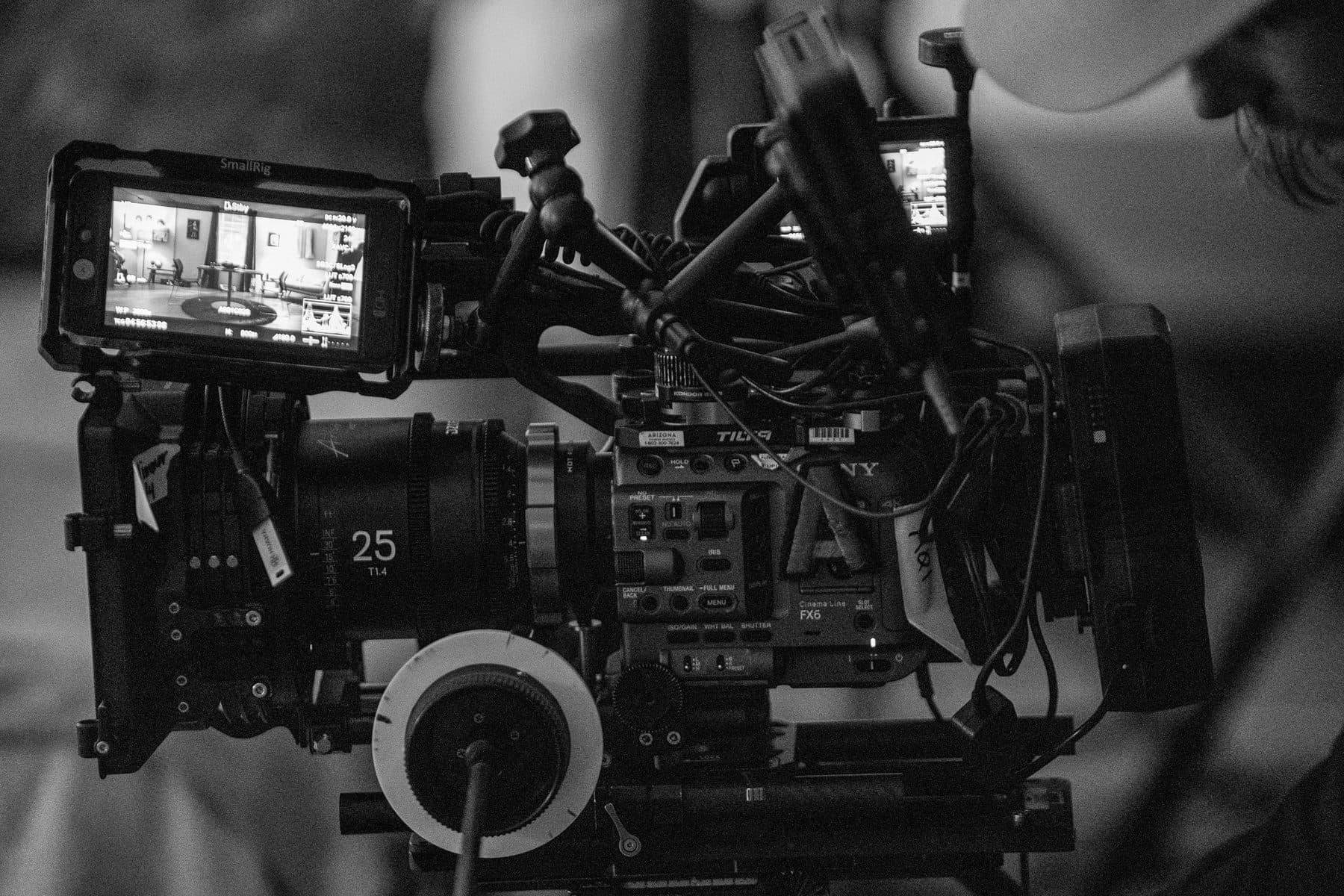 Sony FX6 cinema camera rigged with a DZOFilm Vespid 25mm prime, follow focus and SmallRig monitor, in black and white